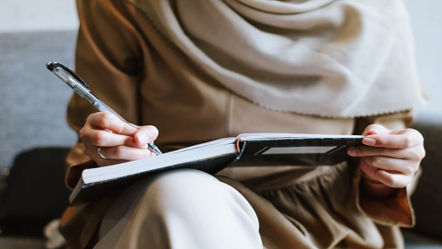 a woman sitting writing in her journal